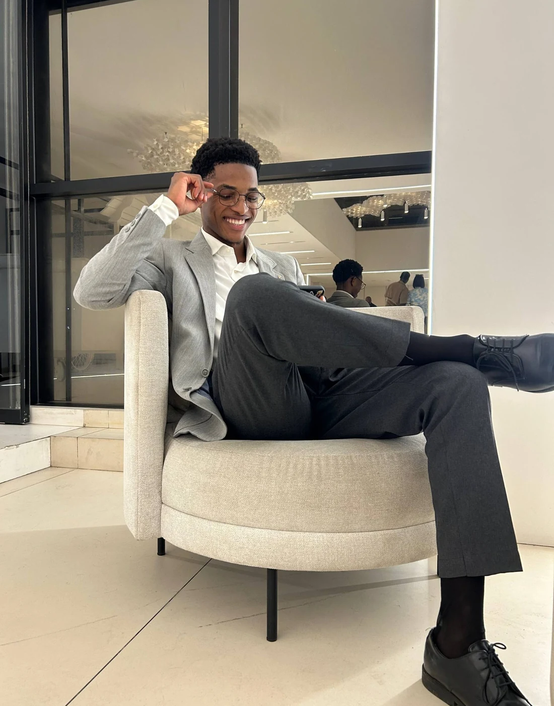 Sacha Jamal, assis dans un fauteuil en tenue professionnelle